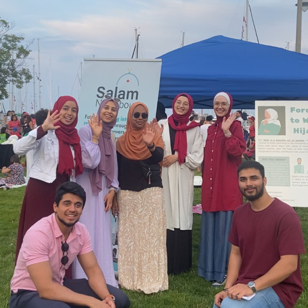 Volunteers waving at camera at midnight madness event